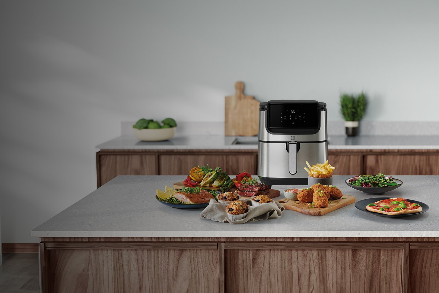 Maträtter står uppradade på tallrikar framför en airfryer från Electrolux.